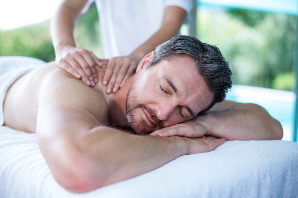 Man receiving back massage from masseur